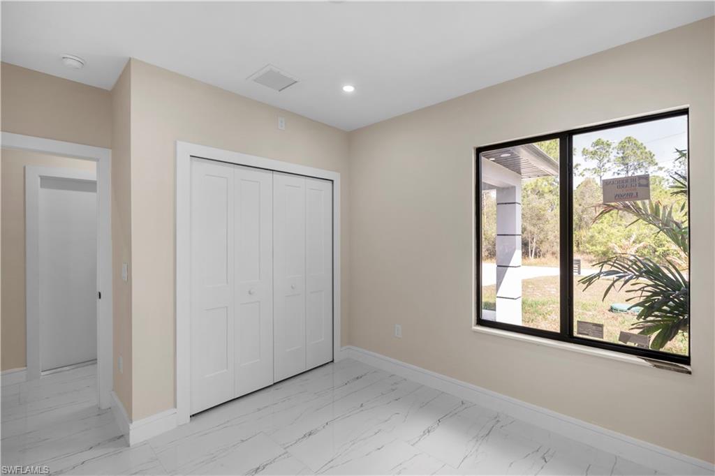 Unfurnished bedroom with light marble finish floors, a closet, and recessed lighting