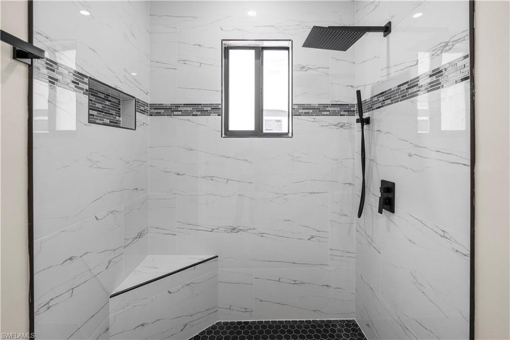 Full bath featuring a marble finish shower