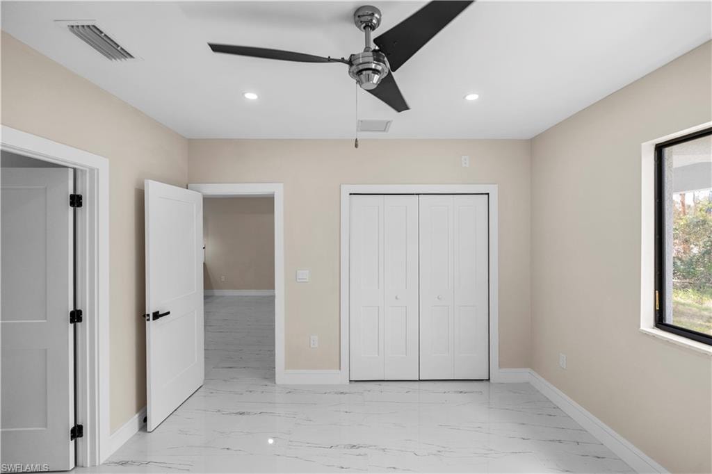 Unfurnished bedroom featuring light marble finish floors, ceiling fan, recessed lighting, and a closet