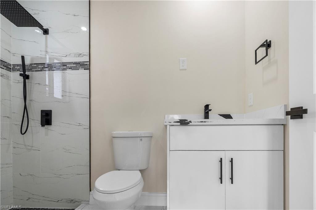 Bathroom with vanity and a marble finish shower