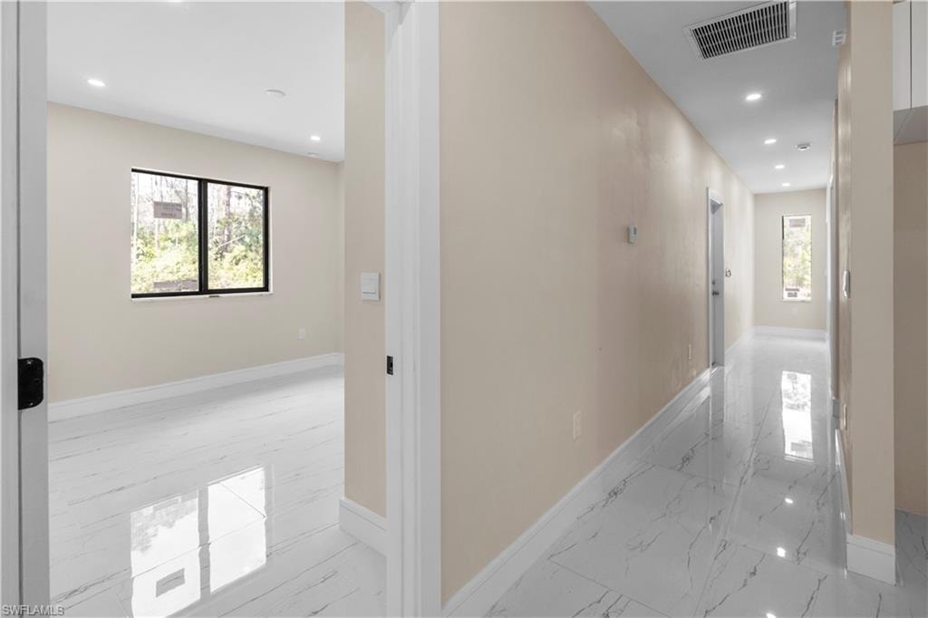 Corridor with recessed lighting and light marble finish flooring