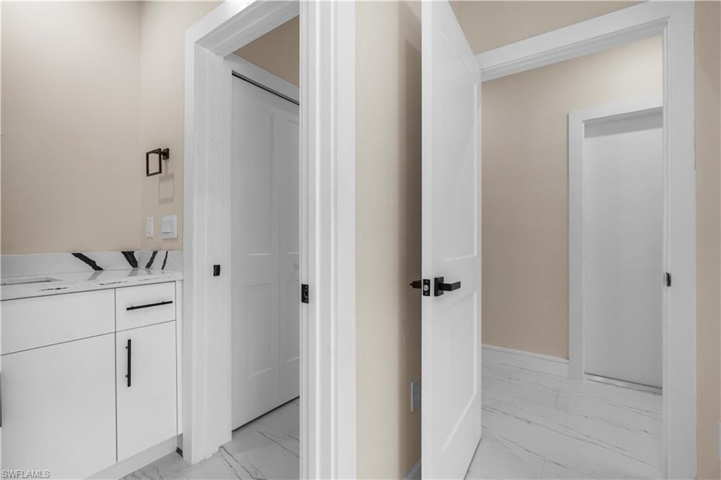 Bathroom with vanity and light marble finish flooring