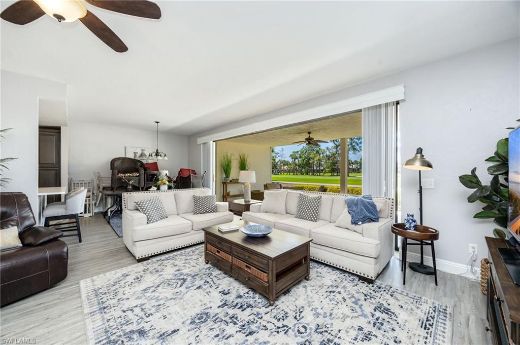 Living area with a ceiling fan, light wood finished floors, and hanging lights