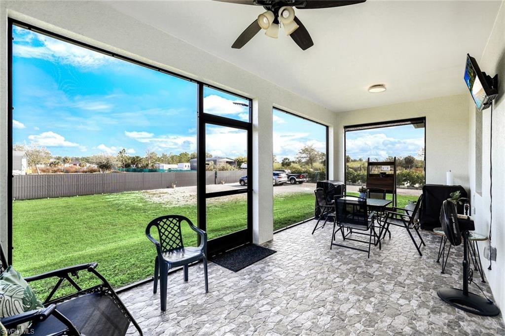 Sunroom featuring a ceiling fan and outdoor dining space