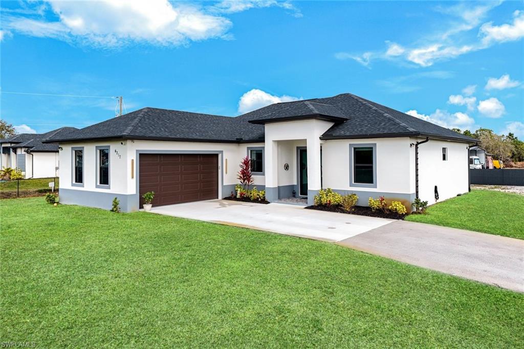 Prairie-style house featuring concrete driveway, an attached garage, stucco siding, and roof with shingles