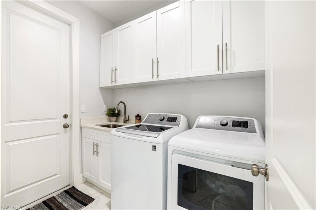 Laundry area featuring cabinet space and separate washer and dryer