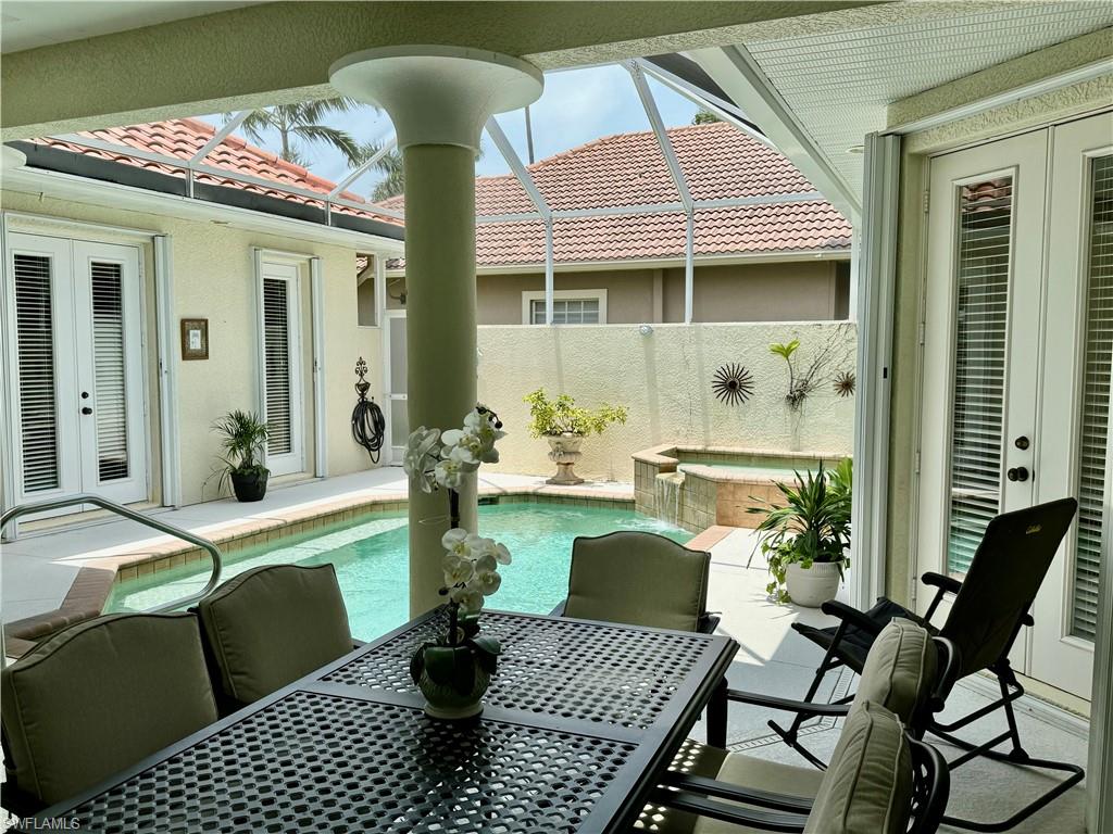 View of patio with french doors, outdoor dining space, and a sunroom