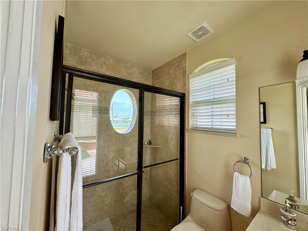 Bathroom featuring a stall shower, plenty of natural light, and vanity