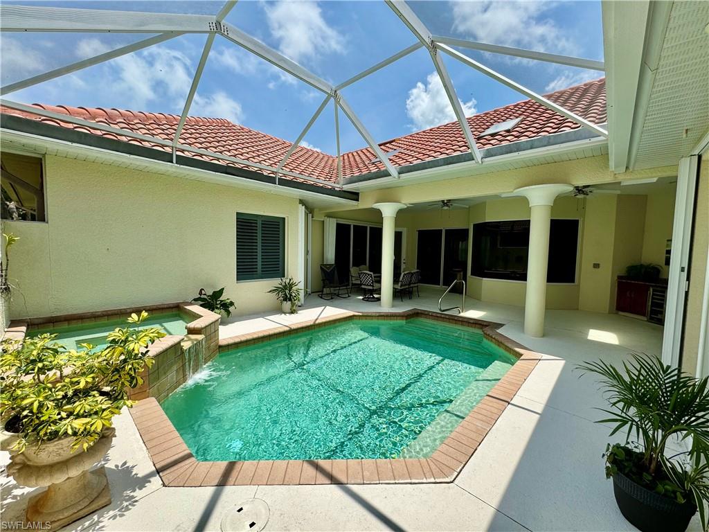 Relaxing pool / spa with a patio, a sunroom, and a lanai