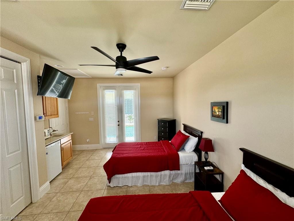 Bedroom with access to outside, light tile patterned floors, french doors, and ceiling fan