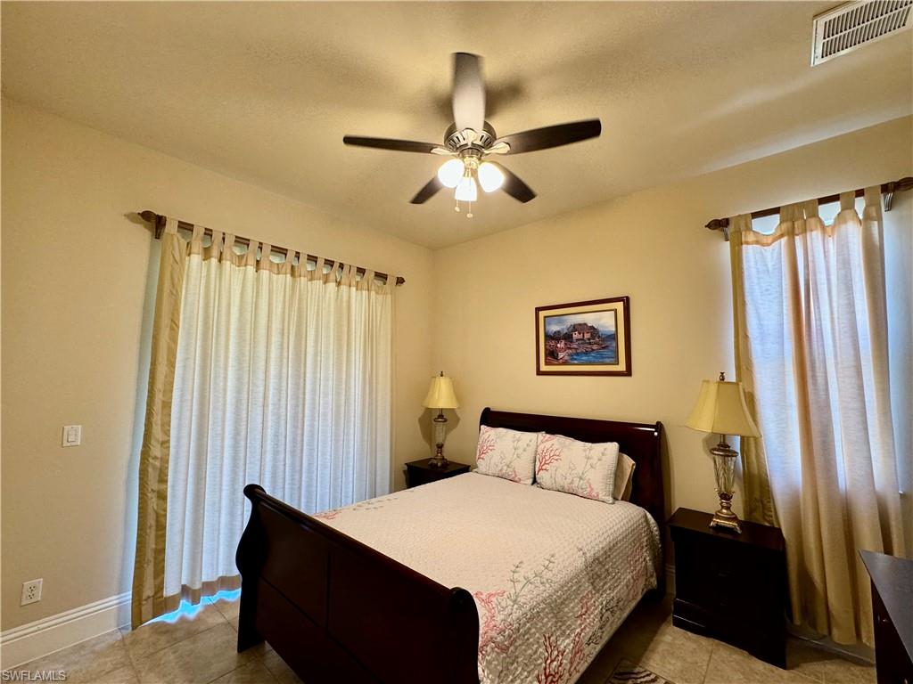 Bedroom featuring light tile patterned floors and ceiling fan