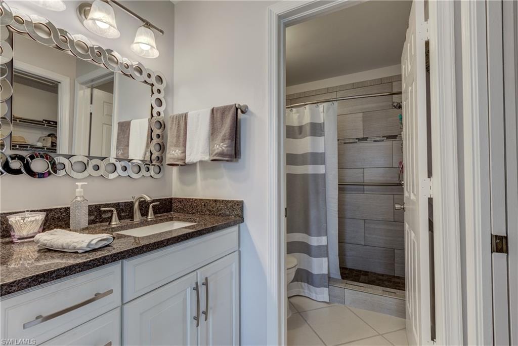 Full bathroom featuring vanity, a shower stall, and light tile patterned floors