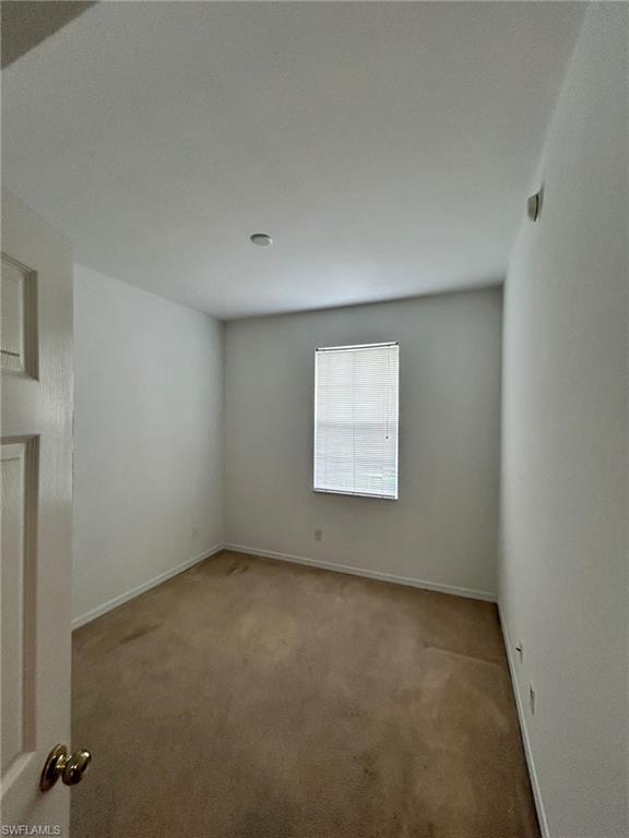 Carpeted empty room with baseboards