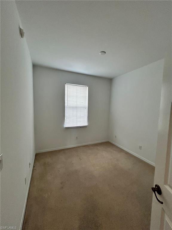 Carpeted empty room with baseboards