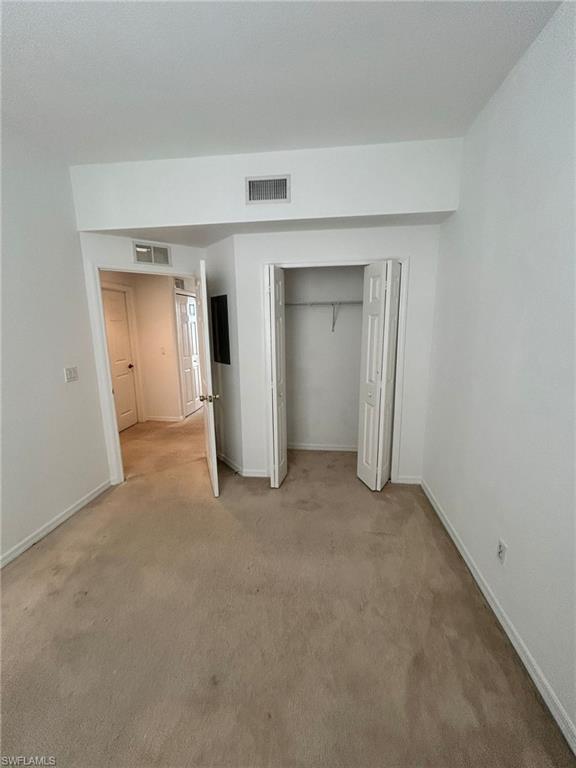 Unfurnished bedroom with a closet and carpet