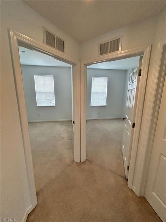 Corridor featuring carpet and baseboards