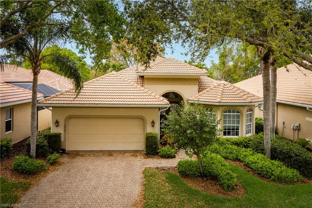 Mediterranean / spanish house with stucco siding, an attached garage, and driveway