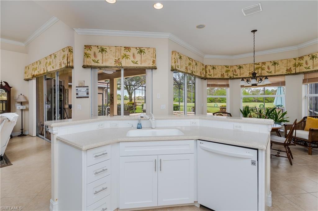 Kitchen featuring dishwasher, light tile patterned floors, white cabinetry, open floor plan, and ornamental molding