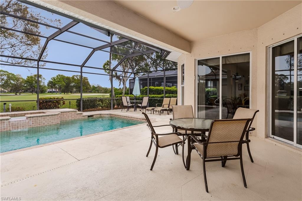 Integrated pool / hot tub featuring a patio, outdoor dining area, a sunroom, a lanai, and golf course view