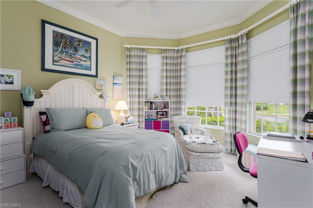 Carpeted bedroom featuring ornamental molding and ceiling fan