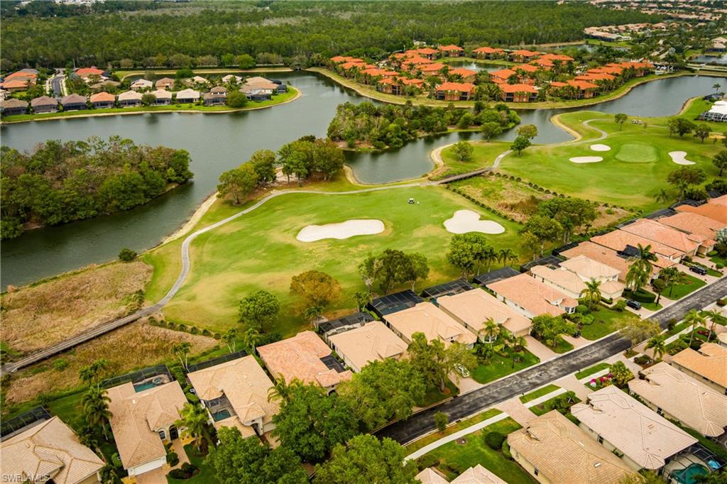 Aerial perspective of suburban area featuring a golf club and a nearby body of water