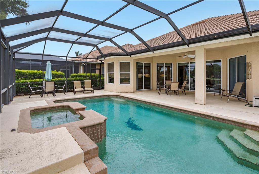 Integrated pool / spa with outdoor dining space, a sunroom, a patio area, and glass enclosure