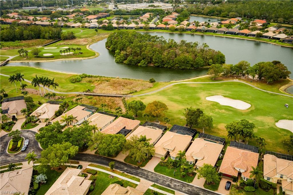 Aerial perspective of suburban area featuring a golf course and a large body of water