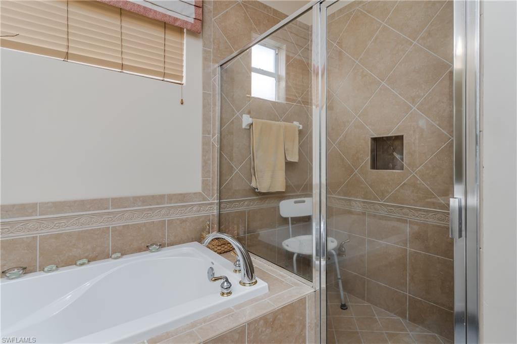 Full bathroom with a stall shower and a garden tub