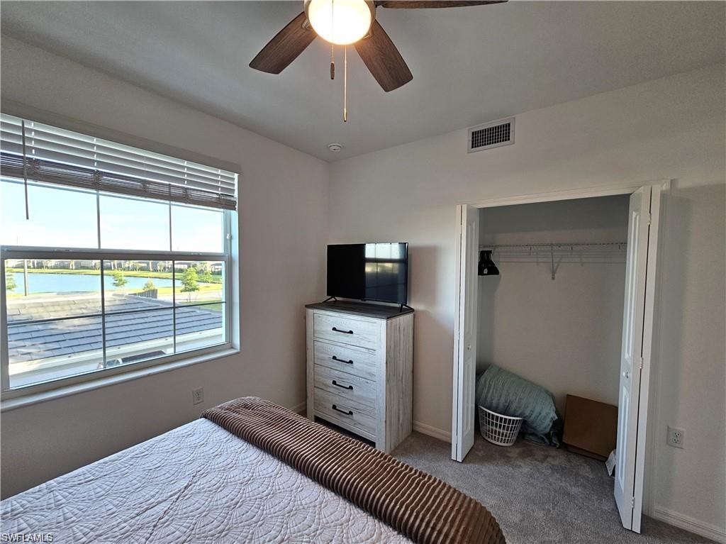 Bedroom featuring a closet, a ceiling fan, baseboards, visible vents, and carpet