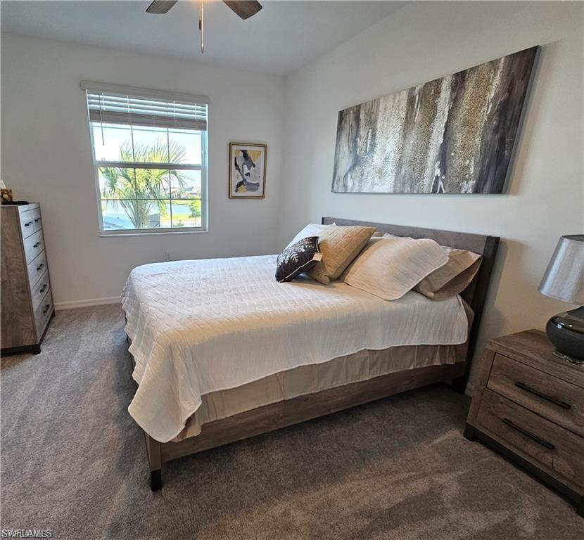 Carpeted bedroom with baseboards and a ceiling fan