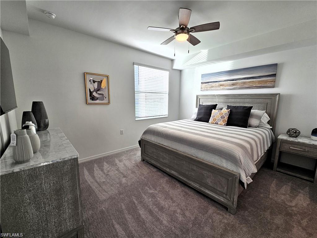 Bedroom featuring baseboards, ceiling fan, and dark carpet