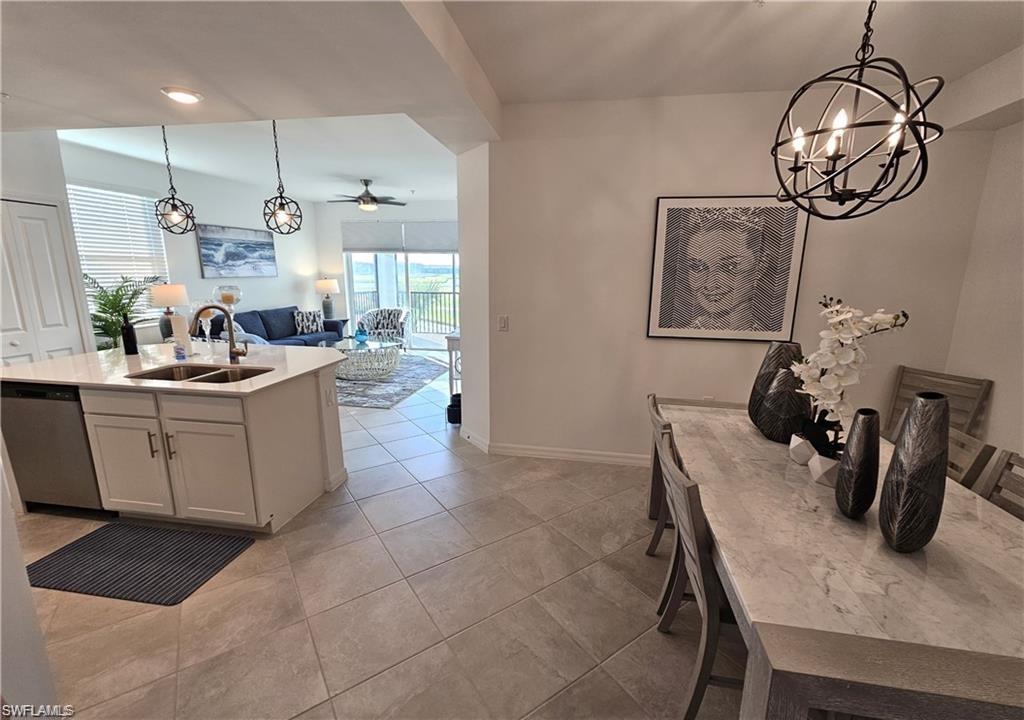 Kitchen with dishwasher, open floor plan, a sink, and decorative light fixtures