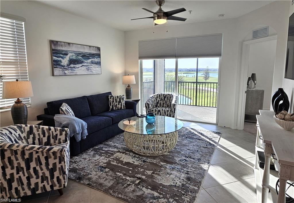 Living area with light tile patterned floors, visible vents, and a ceiling fan