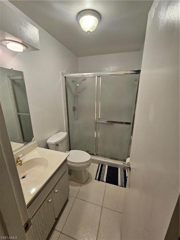 Full bath featuring vanity, a stall shower, and light tile patterned floors