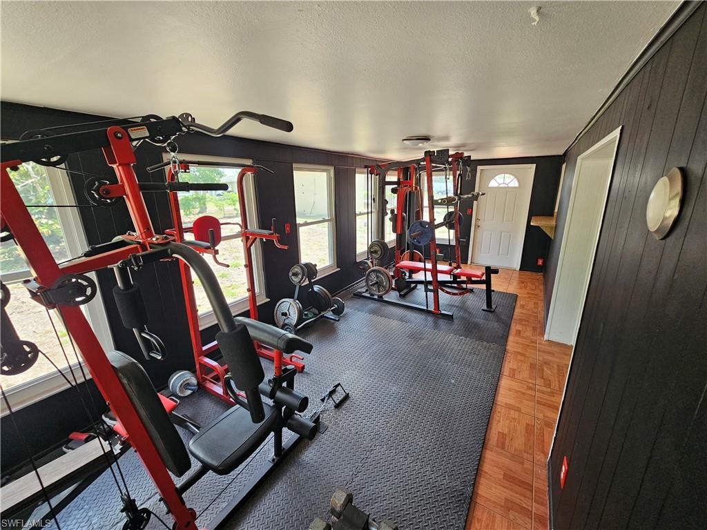 Workout room featuring a textured ceiling and wooden walls