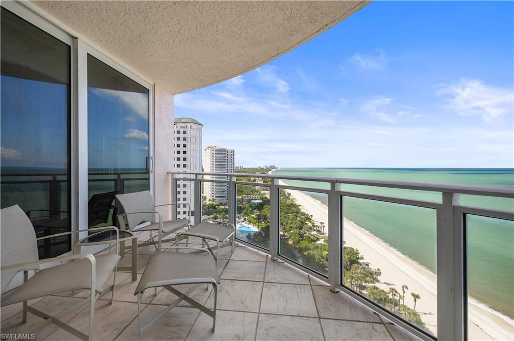 Balcony featuring view of water and beach