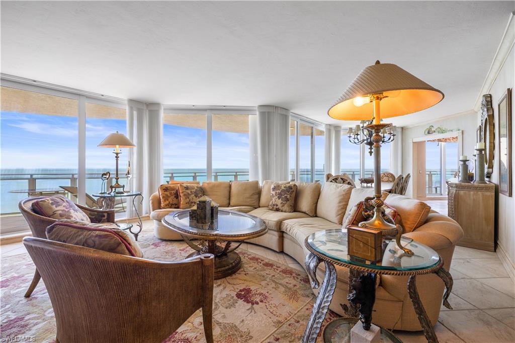 Living area featuring a water view, light tile patterned flooring, and suspended lighting
