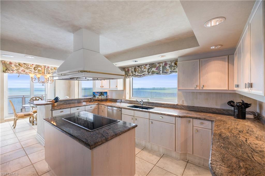 Kitchen featuring a peninsula, a center island, island exhaust hood, black electric cooktop, and stainless steel dishwasher