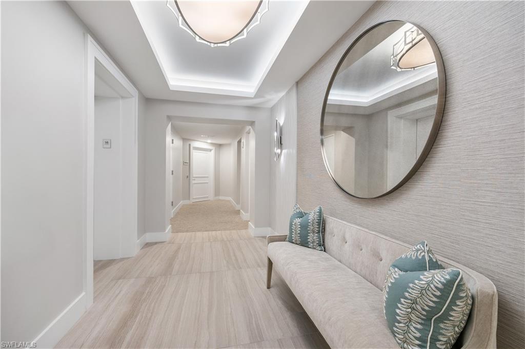 Building Hallway featuring baseboards and a tray ceiling