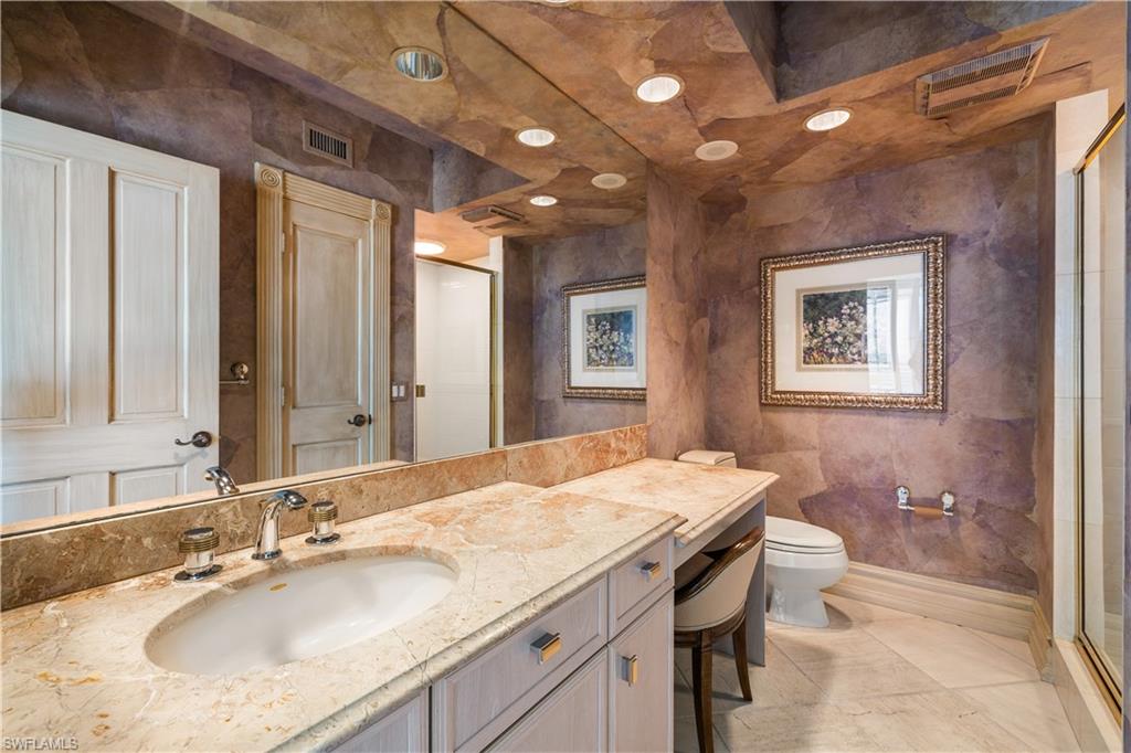 Bathroom featuring vanity, a shower stall, tile walls, and recessed lighting