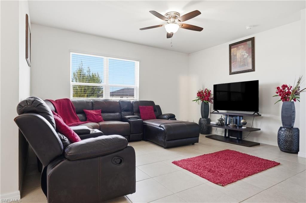 Living room with ceiling fan and light tile patterned floors