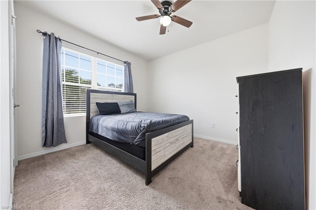 Bedroom with light carpet, lofted ceiling, and ceiling fan