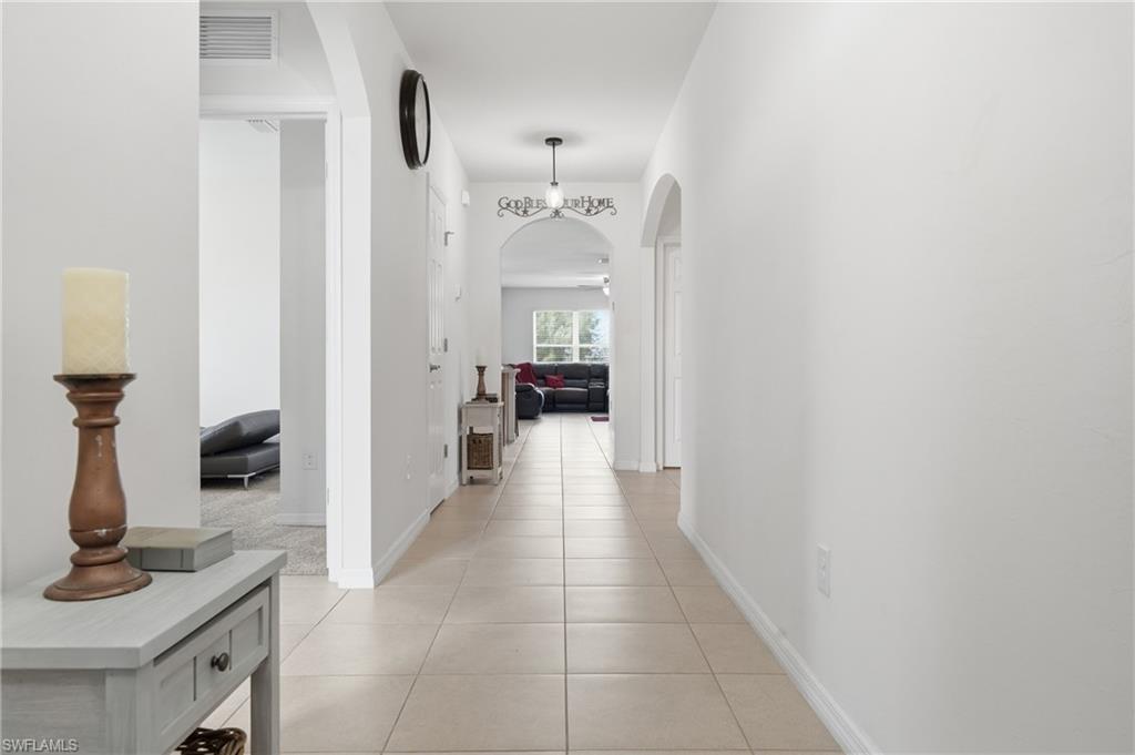 Hall with arched walkways and light tile patterned floors