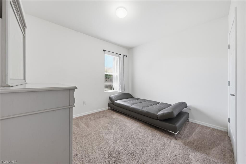 Bedroom with light colored carpet and baseboards