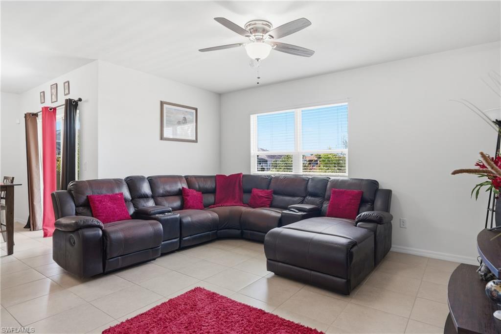 Living room with ceiling fan and light tile patterned floors