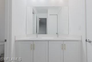 Full bathroom featuring double vanity and toilet