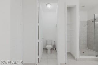 Bathroom featuring a shower stall and light tile patterned floors