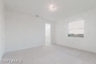 Unfurnished room featuring light carpet