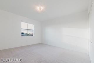 Empty room featuring light carpet