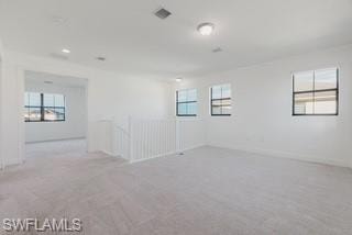 Carpeted spare room featuring baseboards